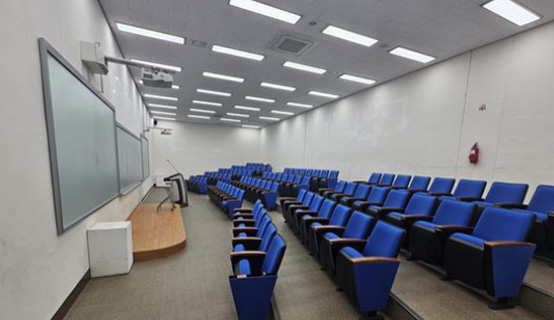 체력단련실에서 러닝머신을 작동시키는 학생